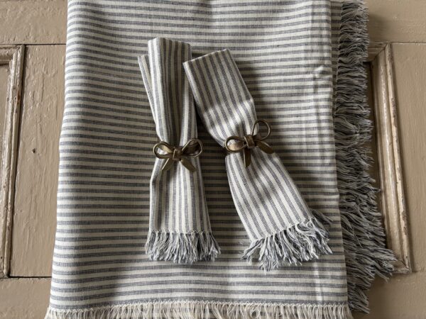 Blue, ticking stripe, tablecloth with frayed edge.
